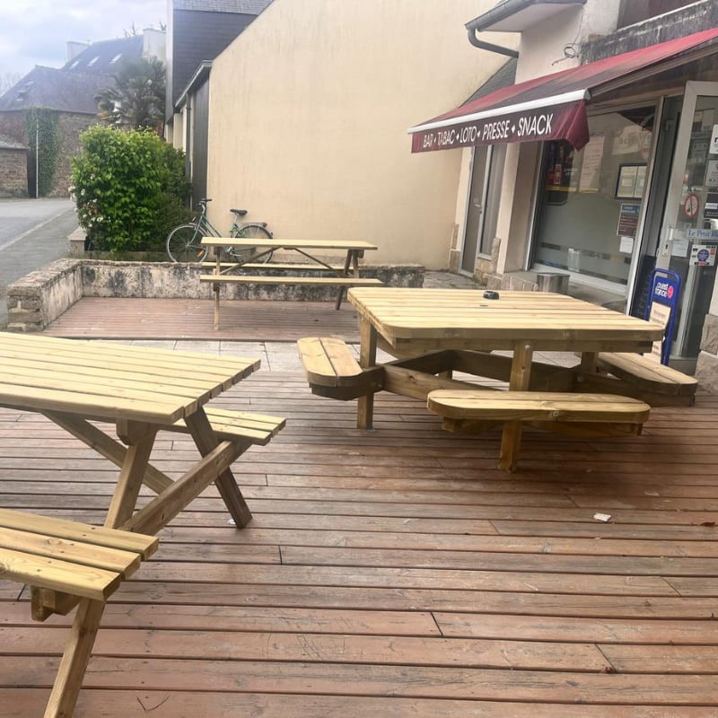 Terrasse en bois d'un commerce avec des tables de pique nique en bois